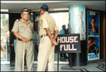 Policemen on guard outside a Bombay cinema hall