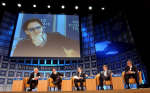 Bono, lead singer of the rock group U2, is seen on a closed circuit television screen during a panel discussion