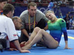 Canadian gymnast Emilie Fourner grimaces as she has her ankle looked at by a doctor
