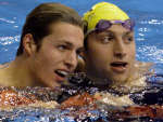 Pieter van den Hoogenband (L) and Ian Thorpe look at the clock after the men's 200m freestyle final. REUTERS/Mark Baker 